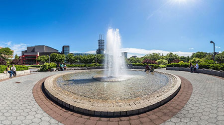 A still photo from the virtual tour experience showing the fountain in front of the Charles B. Wang Center.