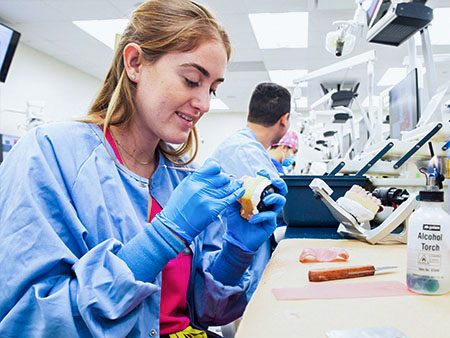 A dental school student in a lab.