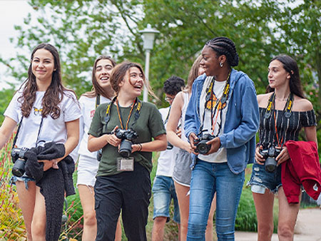 A group of high school students walking with DSLR cameras.