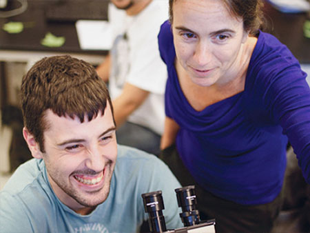 A student using a microscope in a lab.